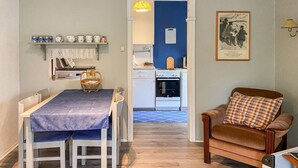 Un espacio habitable compacto con comedor, kitchenette y zona de estar.