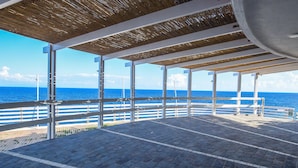An open-air deck with a view of the sea, featuring a wooden ceiling and white railings. - 3 bedroom nice apartment in Rio Marina (Rio Marina)