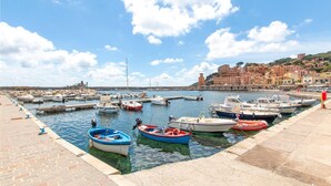 A marina with various boats docked, a clear sky, and a coastal town in the background. - 3 bedroom nice apartment in Rio Marina (Rio Marina)