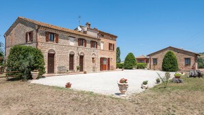 A stone building with a tiled roof, multiple doors, and windows with shutters. - Lovely home in Tolentino with kitchen (Tolentino)