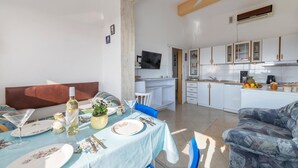 A compact living space with a dining area, kitchen, and a small TV. - Nice apartment in Barbariga with WiFi (Barbariga)