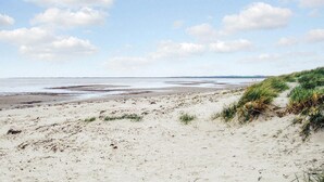 A beach with sand and dunes, a clear sky, and a distant shoreline. - Gorgeous home in Grevinge with kitchen (Grevinge)