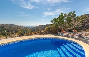 A swimming pool with a view of a hilly landscape and the sea in the background. - Awesome home in Torrox (Torrox)