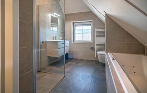 Bathroom features a glass shower enclosure, vanity, and separate toilet area.