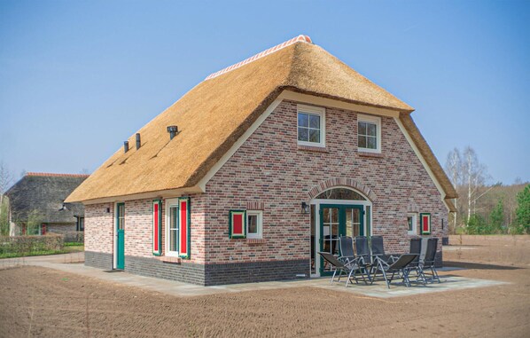 Traditional brick building with a steeply pitched roof, central entrance, and charming porch area.