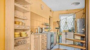 Una cocina con armarios de madera, estufa y pileta.