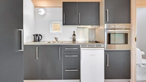 Una cucina moderna con mobili grigi, una cappa aspirante in acciaio inossidabile e un forno integrato.