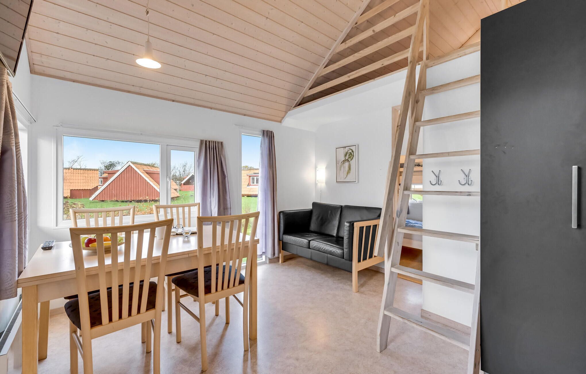 A cozy living space with a dining area, a sofa, and a ladder.