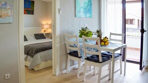 A small, bright room with a bed, a table with chairs, and a window with curtains. - 1 bedroom awesome apartment in Rovinj (Rovinj)