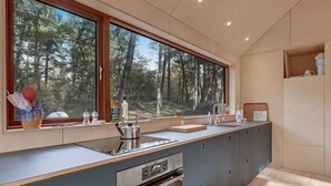 A modern kitchen with a large window, built-in oven, and a sink. - Nice home in Nexø with WiFi (Nexø)