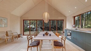 A spacious dining area with a high ceiling, large windows, and a view of the forest. - Nice home in Nexø with WiFi (Nexø)
