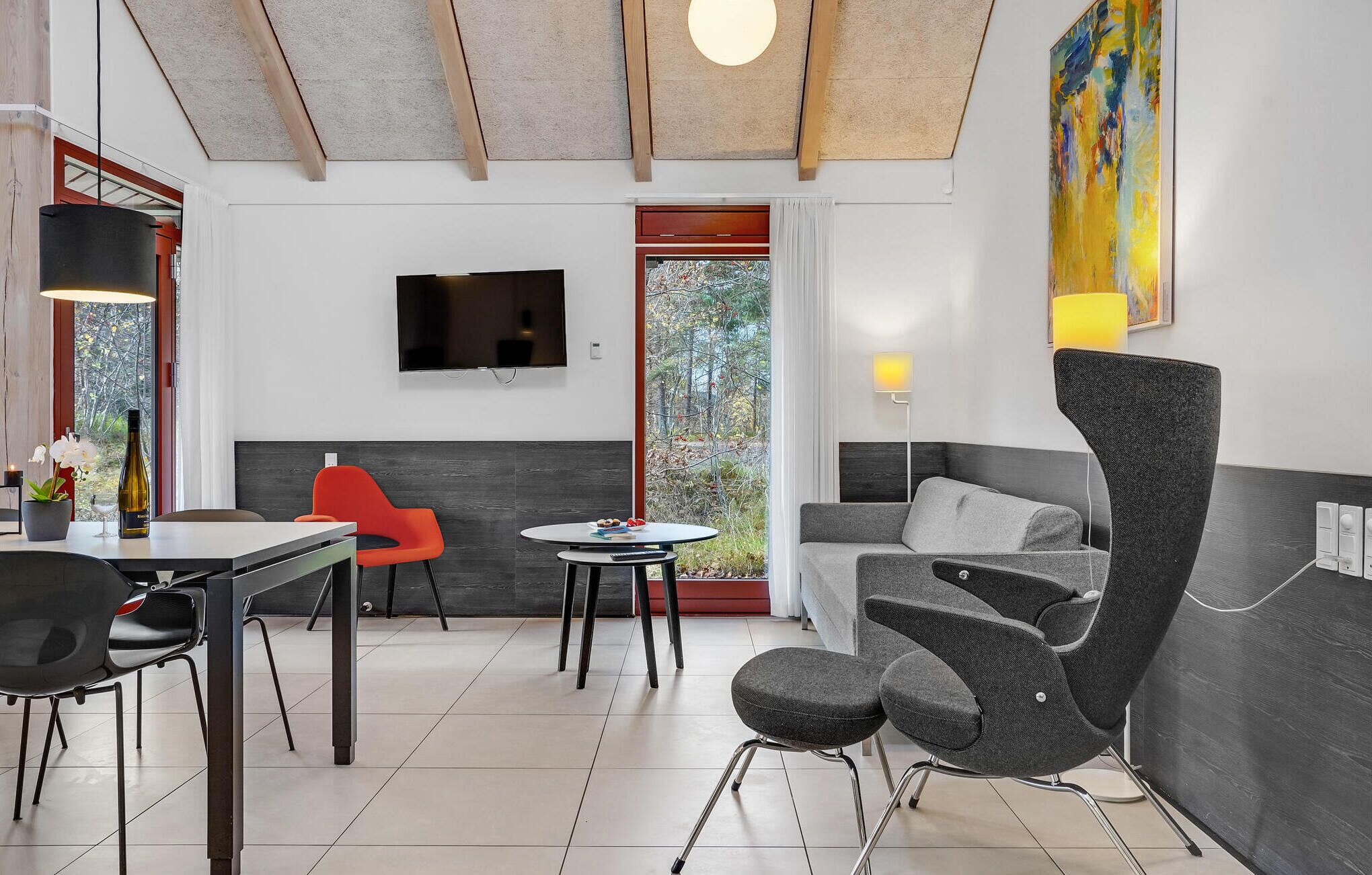 Un intérieur moderne comprenant un coin repas, un canapé et un téléviseur fixé au mur.
