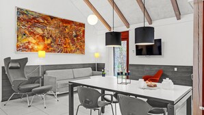 A modern dining area with a large abstract painting, a sofa, and a dining table with chairs. - Gorgeous home in Grenaa with WiFi (Grenaa)
