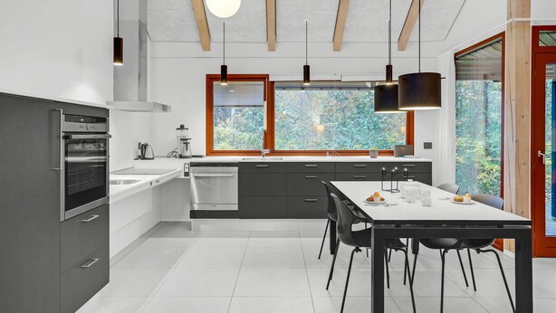 Una cucina moderna con forno integrato, lavastoviglie e un'ampia finestra con vista sull'esterno.