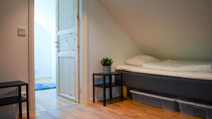 A bedroom with a bed, a small table with a plant, and a storage unit under the bed. - 2 bedroom amazing home in Fjälkinge (Fjälkinge)