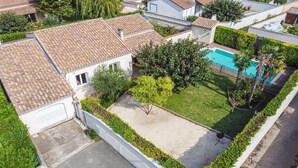 Un immobile residenziale con piscina, giardino recintato e garage.