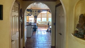 A hallway with a tiled floor, a kitchen area with a dining table and chairs, and a living room with a sofa and a coffee table. - FABULOUS BEACH HOUSE- 7 Bedrooms,Heated Pool,12 BeachBadges,9 Car Driveway (Point Pleasant Beach)