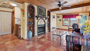 A spacious living area with a fireplace, wooden ceiling, and a colorful sofa. - FABULOUS BEACH HOUSE- 7 Bedrooms,Heated Pool,12 BeachBadges,9 Car Driveway (Point Pleasant Beach)