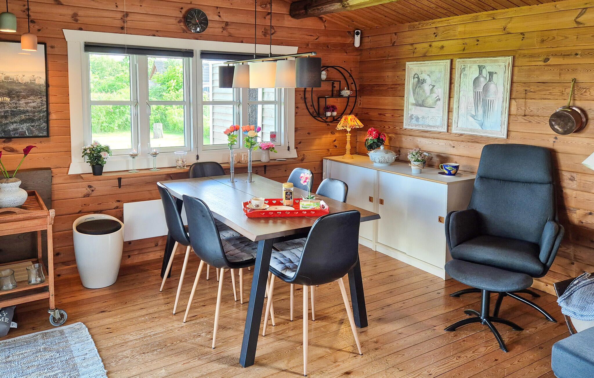 L’intérieur chaleureux d’un chalet comprend une table à manger, des chaises, un canapé et un coin cuisine.