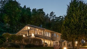 A modern house with a large glass facade, a covered porch, and a well-maintained lawn. - Lovely home in Uddevalla with kitchen (Uddevalla)