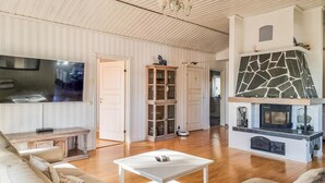 A spacious living room with a fireplace, a television, and a dining area. - Lovely home in Uddevalla with kitchen (Uddevalla)