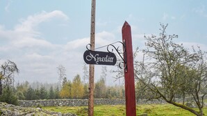 A rustic wooden sign with the name "Hvaslatt" in a mountainous area with stone walls and trees. - Cozy home in Ryd with WiFi (Ryd)