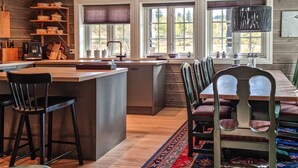 A kitchen with a central island, bar stools, and a dining table with chairs. - Stunning home in Hovden i setesdal (Hovden i setesdal)