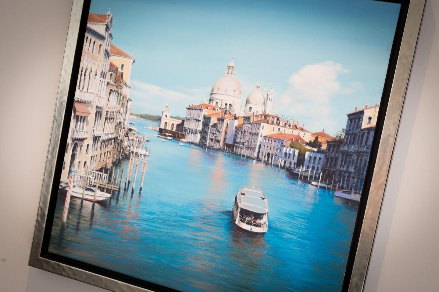 Dipinto incorniciato di un canale con edifici e una barca.