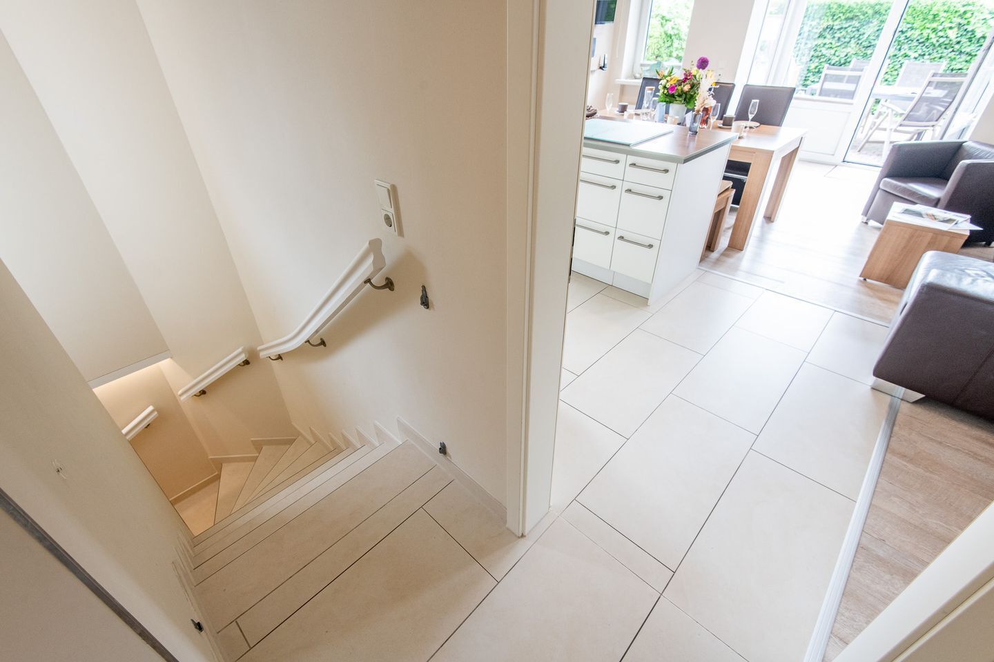 A modern interior with a staircase leading to a dining area.