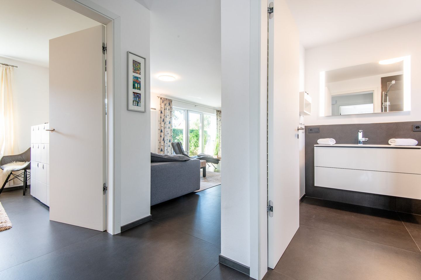 Een moderne hotelkamer met een groot bed, een badkamer met een spiegel en wastafel, en uitzicht op het omliggende landschap.