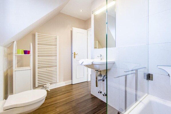 A modern bathroom with a toilet, sink, and glass shower enclosure. - House Nordhedig 1, Whg. 4 - House Nordhedig (Sylt)