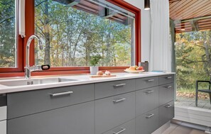 A modern kitchen with a large window, grey cabinets, and a stainless steel sink. - 2 bedroom beautiful home in Grenaa (Grenaa)
