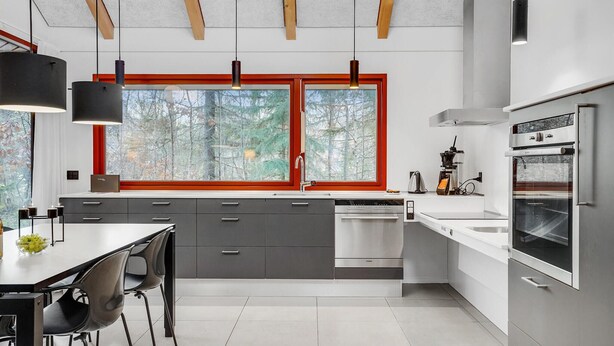 A modern kitchen with grey cabinets, a white countertop, a built-in oven, and a window with red frames. - Nice home in Grenaa with WiFi (Grenaa)