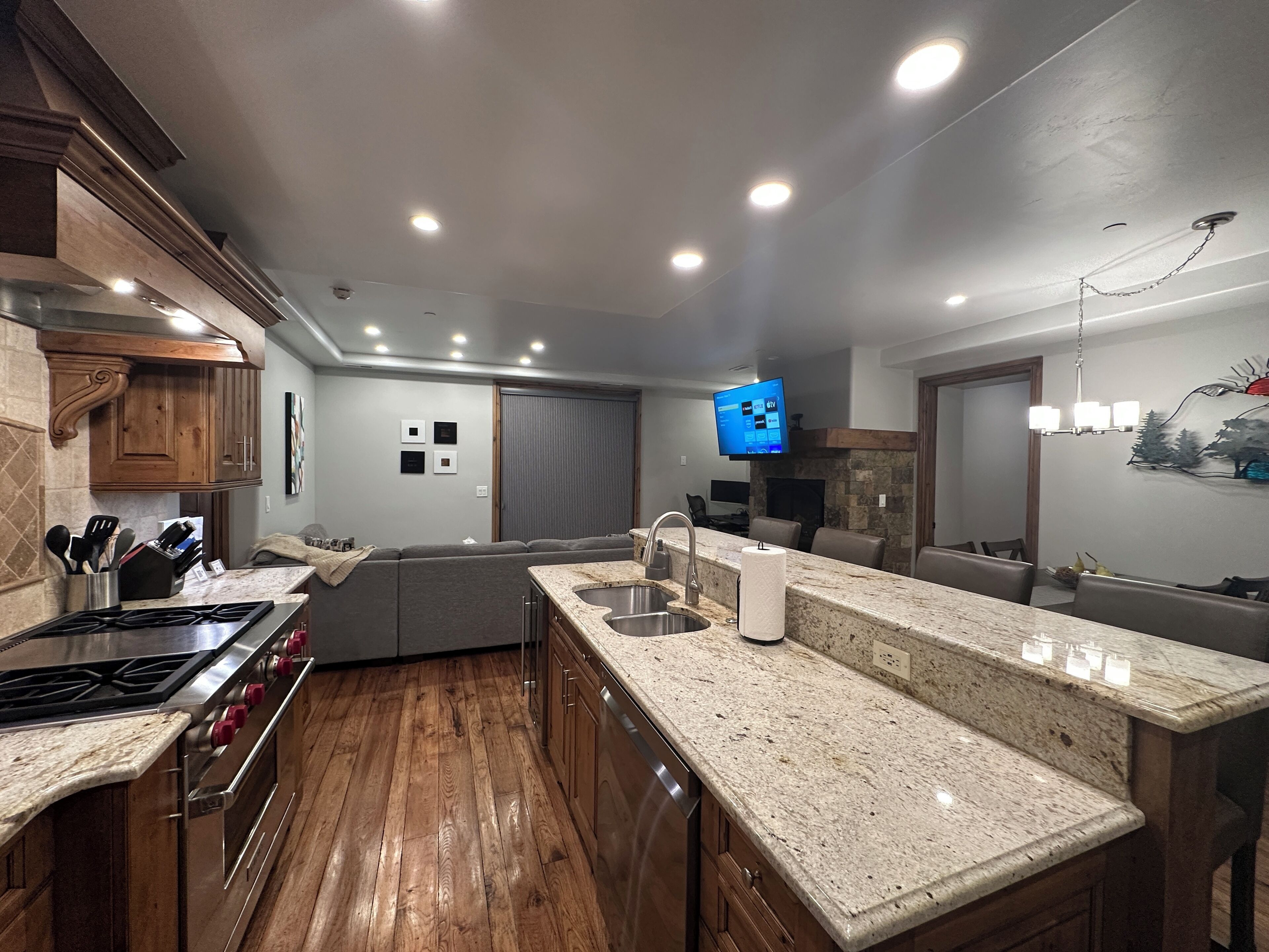 A modern kitchen with wooden cabinets, granite countertops, and a built-in stove.