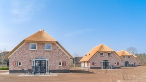 Un hilera de edificios de ladrillo con tejados a dos aguas y una entrada central.