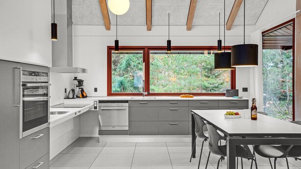 A modern kitchen with a large window, built-in appliances, and a dining area. - Beautiful home in Grenaa with WiFi (Grenaa)