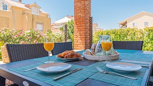 An outdoor dining table with a croissant, two glasses of orange juice, and a bottle of water. - Beautiful home in Vodice with sauna (Vodice)