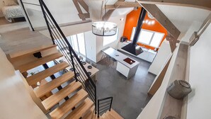 Une cuisine moderne dotée d’un îlot central, d’un coin repas et d’un escalier menant à un niveau supérieur.
