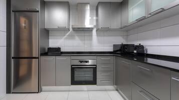 Een oven, een vaatwasser, een broodrooster, kookgerei, borden en bestek