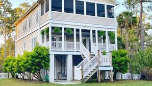 A two-story house with a balcony, a staircase, and a front porch. - Large Home w 2 Airstream Glampers & Spa near Beach & Downtown (Savannah)