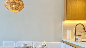 Une cuisine moderne avec un banc en bois, un luminaire suspendu et un évier encastré.