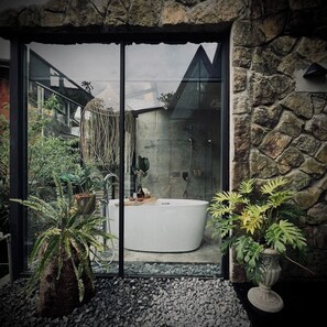 A modern bathroom with a large bathtub, a shower, and a glass-enclosed shower area. - Twilight Forest (New Taipei City)