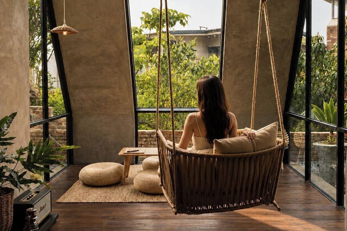 A room with a hanging chair, a small table, and a radio.
