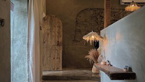 A hallway with a wooden door, a stone wall, and a hanging light fixture. - Twilight Forest (New Taipei City)
