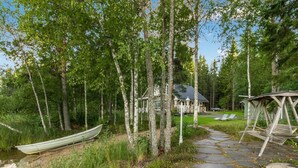 A stone pathway leading to a wooden cabin surrounded by birch trees. - Torniniemi by Interhome (Punkaharju)
