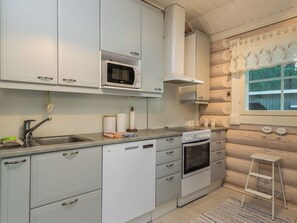 Una cocina con armarios blancos, un microondas, una estufa y un lavabo.