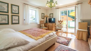Ein Schlafzimmer mit Bett, Schreibtisch, Fernseher und Stuhl.