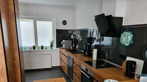 Una cocina moderna con encimera de madera, lavavajillas integrado y estufa negra.