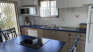 Una cocina compacta con microondas, fregadero y estufa.