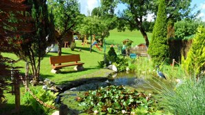 A park with a pond, benches, and playground equipment.